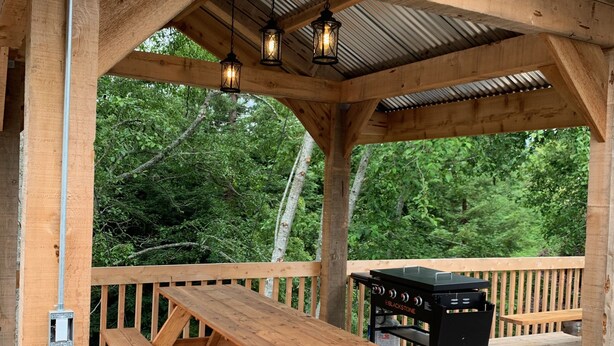 A wooden deck with a picnic table and a grill. - Macklyn Creek retreat (Brookings)