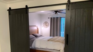 A bedroom with a bed, a ceiling fan, and a window with curtains. - Macklyn Creek retreat (Brookings)