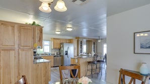 Una cocina moderna con armarios de madera, una mesa de comedor con sillas y una isla grande con fregadero.