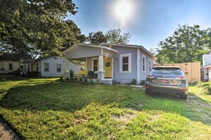 A single-story house with a porch and a car parked in the driveway. - 1 Mi to UTA: Arlington Elm Cottage w/ Fenced Yard (Arlington)