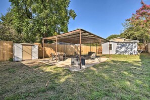 Relax in a shaded patio area surrounded by lush greenery and comfortable seating.