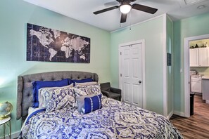A bedroom with a bed, a globe, a world map, a ceiling fan, and a kitchen area. - 1 Mi to UTA: Arlington Elm Cottage w/ Fenced Yard (Arlington)