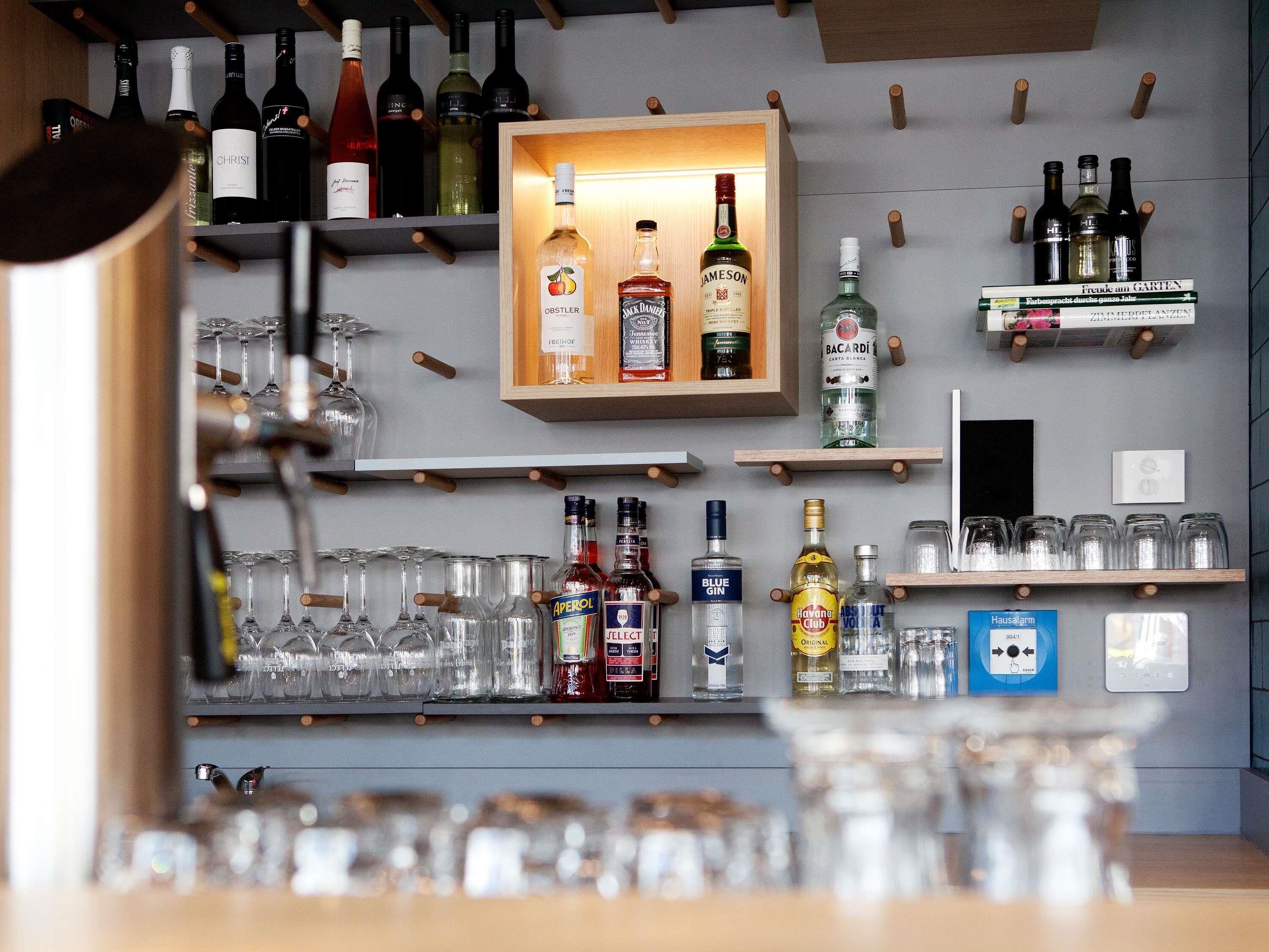 A bar area with shelves of liquor bottles and glasses.