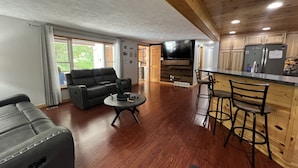 A modern kitchen with wooden cabinets, a built-in oven, and a bar area. - Cozy Cottage (Roscommon)