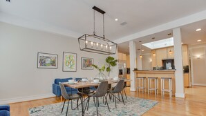 Un espace repas moderne avec une table en bois, des chaises et un luminaire suspendu.