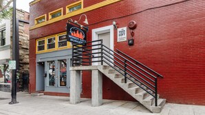 A red brick building with a sign for 'Windy City Burgers' and a staircase leading to the entrance.