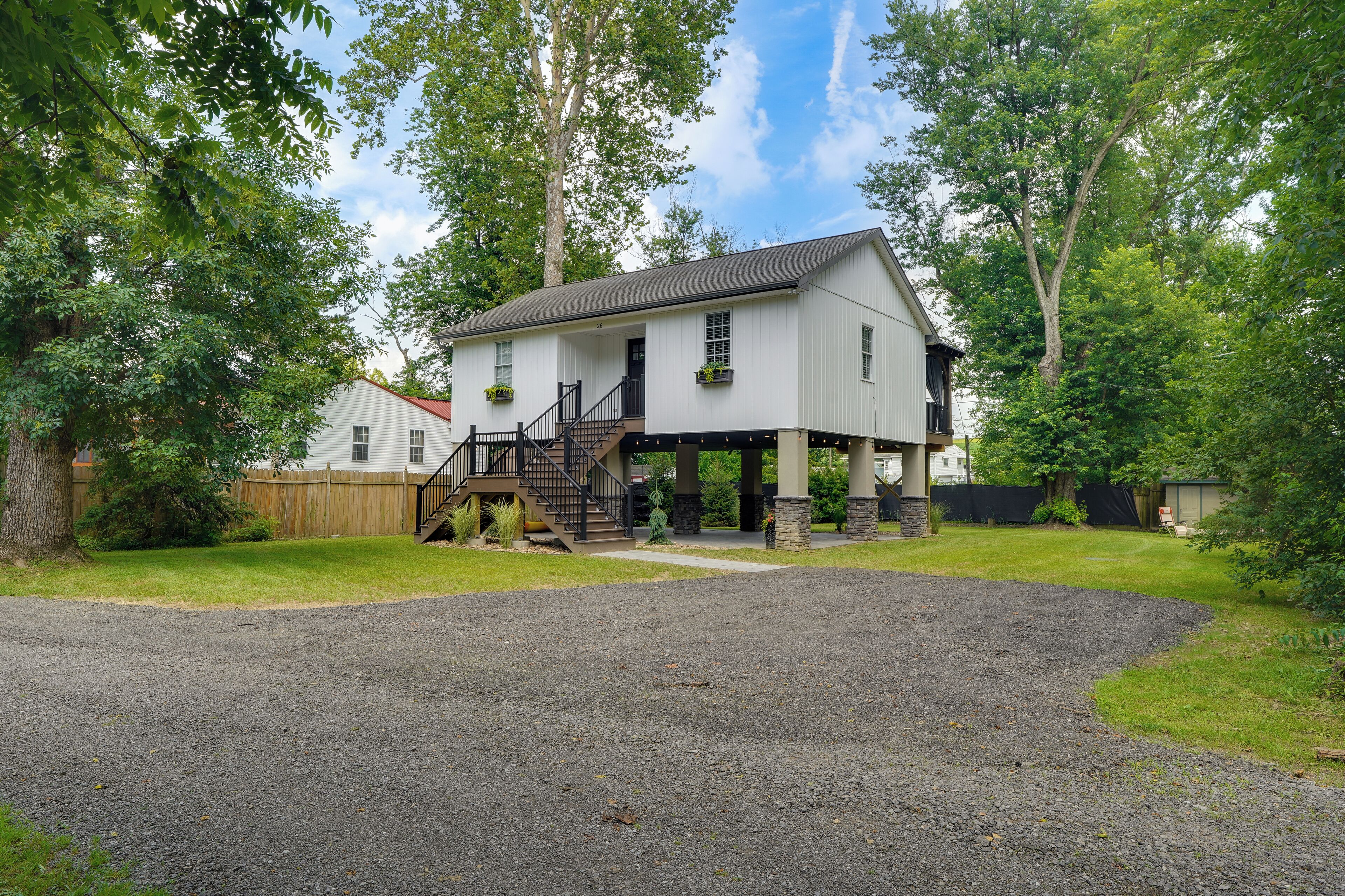 A two-story house with a front porch, a staircase, and a driveway.