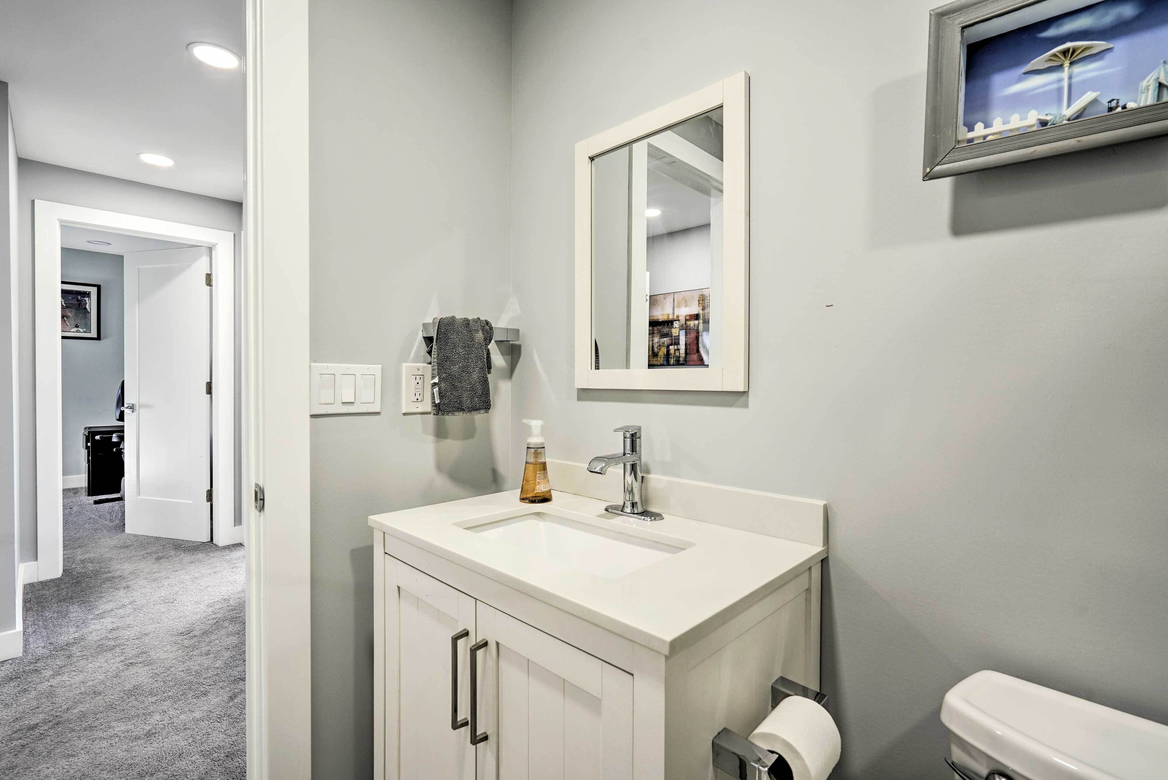 A bathroom with a white sink, a mirror, and a toilet.