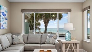 Ein Wohnzimmer mit Sofa, Couchtisch und Blick auf den Strand.