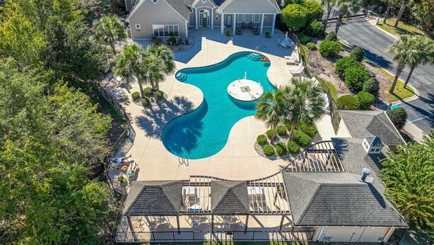 A large house with a swimming pool, surrounded by palm trees and a well-maintained lawn. - Great Location minutes from Golfing & the Beach! (Myrtle Beach)