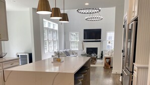A modern kitchen with a marble island, pendant lights, and a built-in oven. - SARATOGA DREAM!-Lake community close to Track and Downtown (Saratoga Springs)