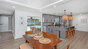 Una cocina moderna con armarios grises, una isla central e iluminación colgante.