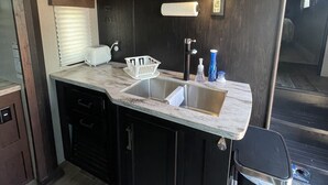A compact kitchen with a sink, countertop, and cabinets.