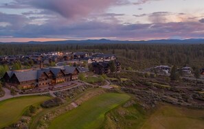 A lodge with multiple buildings, a golf course, and a forested backdrop. - Stone - Tetherow, Hot Tub, Gas Fire Pit, BBQ, Executive Retreat (Bend)