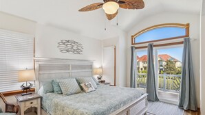 A bedroom with a large bed, a ceiling fan, and a view of the outside. - 220ft from beach access! Private pool, hot tub. Summer deals! (Corolla)