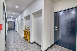 Stylish corridor with a polished floor, white walls, and a console table featuring a potted orchid.