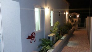 Un edificio con camino de grava, un mural de perro e iluminación exterior.