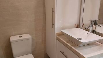 Regadera, secadora de cabello, toallas, papel de baño