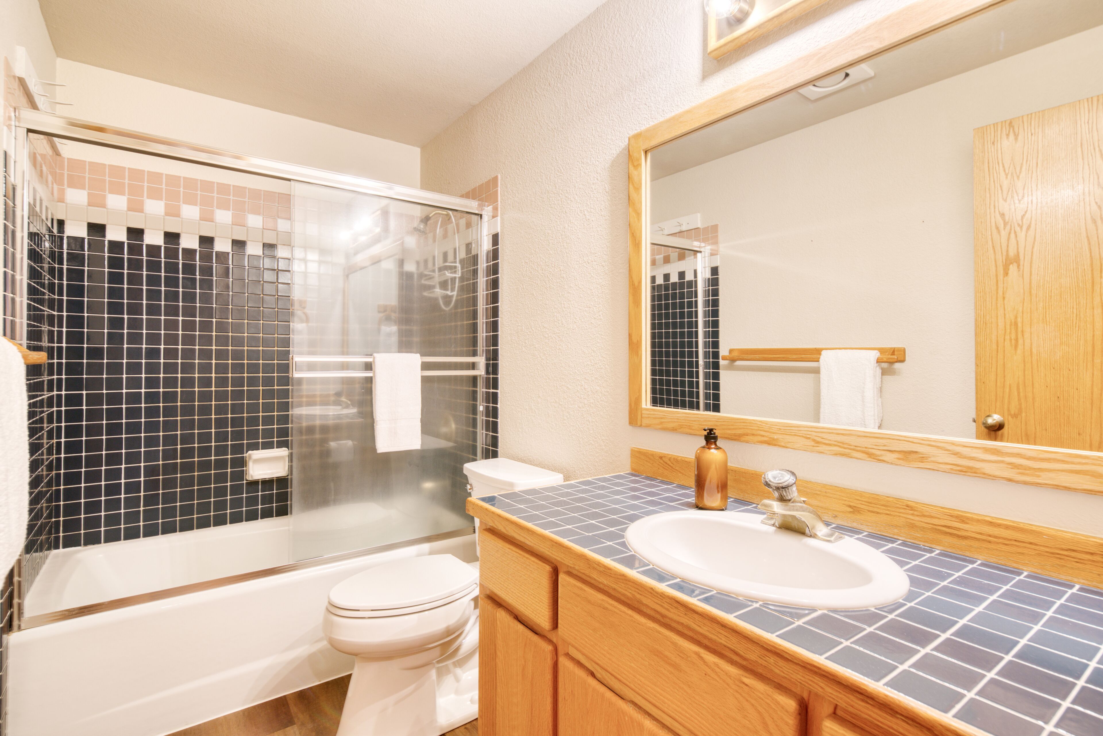 Une salle de bain avec une baignoire, des toilettes, un lavabo et un grand miroir.