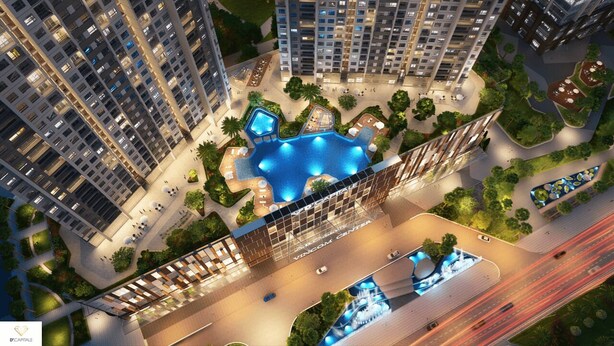 Um edifício residencial alto com um pátio central que possui uma piscina, rodeado por vegetação e caminhos para pedestres.