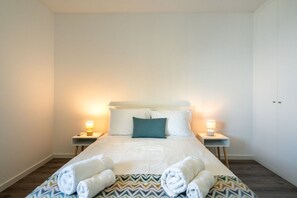 Ein Hotelzimmer mit einem großen Bett, zwei Nachttischen mit Lampen und einem Kleiderschrank.