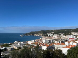 Une ville côtière avec des bâtiments, une plage et un ciel bleu dégagé.