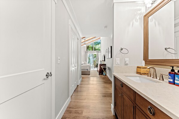 Une salle de bain moderne avec un grand miroir, un lavabo et des meubles en bois.