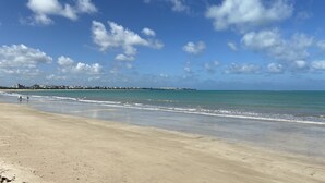Une plage avec un ciel dégagé et une mer calme.