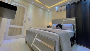 Un dormitorio moderno con cama, mesita de noche y un equipo de aire acondicionado.