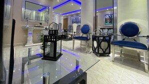 Un interior moderno con una mesa de vidrio, sillas azules y un espejo grande.