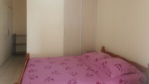 Ein Schlafzimmer mit einem Bett, einem Kleiderschrank und einer Tür.