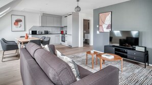 Un apartamento moderno con zona de estar tipo loft, comedor y cocina.