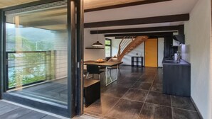 Un intérieur moderne comprenant un coin repas, une cuisine et un escalier.