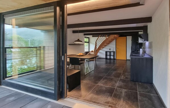 Een modern interieur met een eethoek, keuken en een trap.