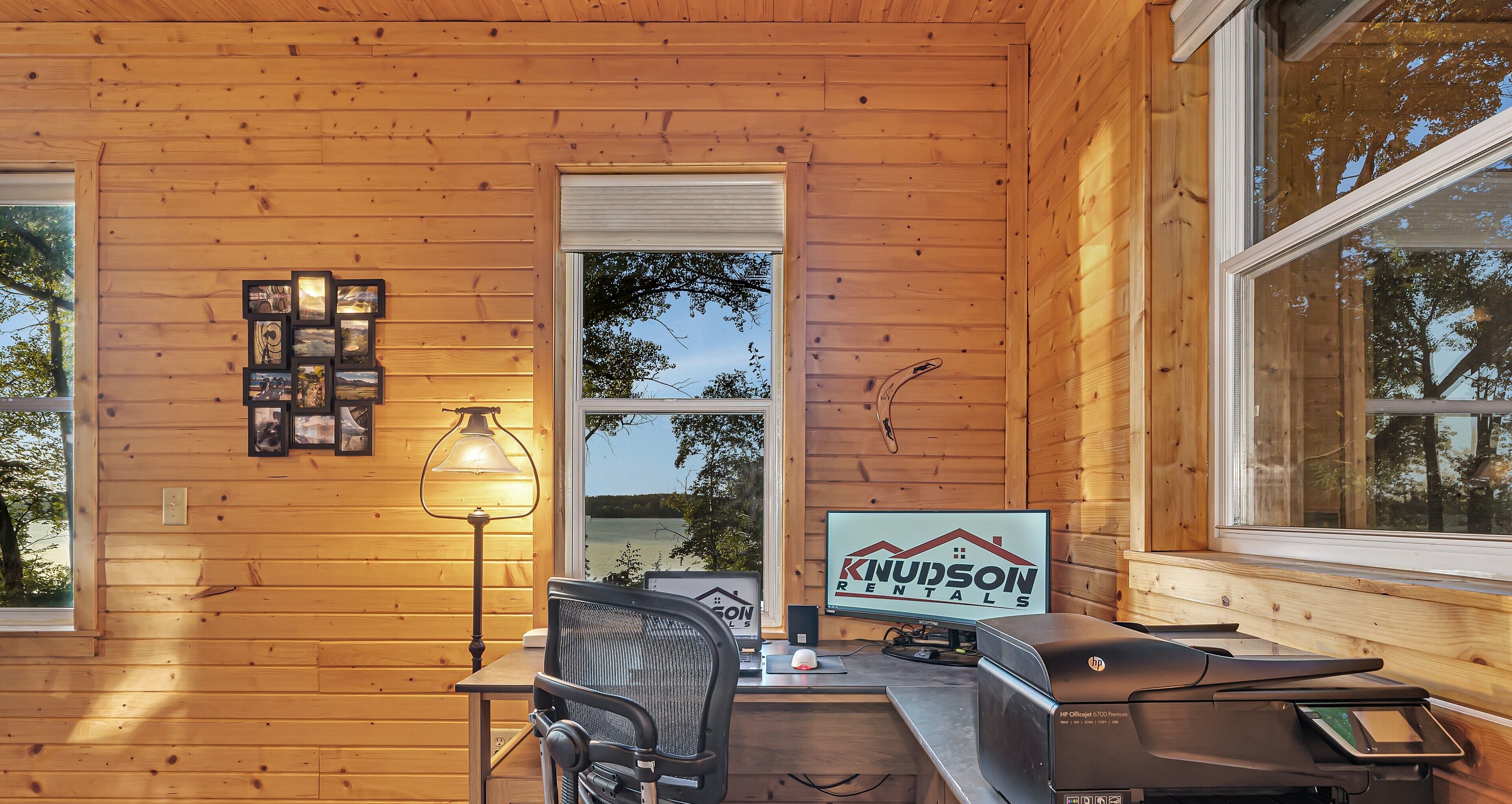 L’intérieur d’une cabane en bois, avec un bureau, une chaise, une lampe et une enseigne indiquant « Knudson Rentals ».
