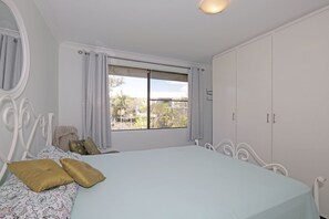 2 dormitorios y tabla de planchar con plancha