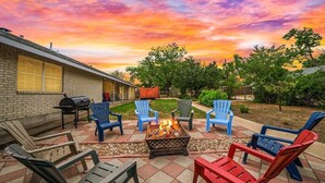 An outdoor patio with a fire pit and seating area.