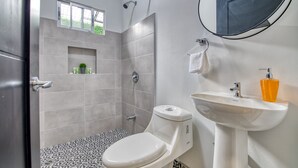 A bathroom with a toilet, sink, and shower.