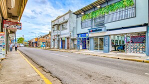 Une rue bordée de divers commerces et un immeuble sur lequel on peut lire l’inscription « A Residencia ».
