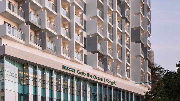 A modern hotel with a prominent sign reading "Grab the Ocean | Songdo". - Grab the Ocean SONGDO (Busan)