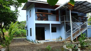 A two-story building with a balcony and a staircase. - Private room for 2 people 26 km from Jaco (San Antonio de Tulín)