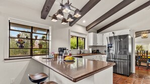 A modern kitchen with a large island, stainless steel appliances, and a view of the outdoors. - Large Spanish Villa ~ Sleeps 14~ Gym ~ GameRm~ Pool ~ Views  (Sedona)