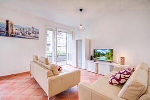 A modern living room with a sofa, a television, and a painting on the wall.