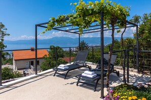 A balcony with two sun loungers, a pergola with climbing plants, and a view of the sea and mountains. - Pool And Garden Apartment Happy Sound, Rijeka, Croatia (Rijeka)