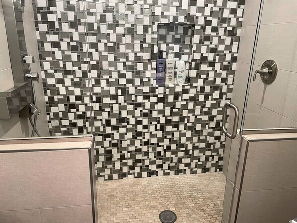 A shower area with a tiled mosaic wall, a handheld showerhead, and a drain. -
⭐Skyline views!⭐ Mins from Downtown and Topgolf! Large Deck, Fenced in yard! (Nashville)