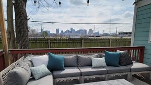 Ein Sitzbereich im Freien mit einer Couch und einem Tisch, mit Blick auf eine Stadtlandschaft.