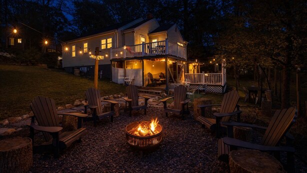 A house with a deck, outdoor seating, and a fire pit.