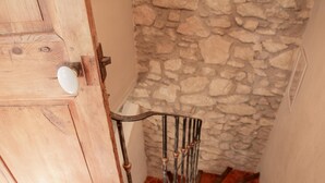 Una porta in legno con maniglia metallica e un muro in pietra.