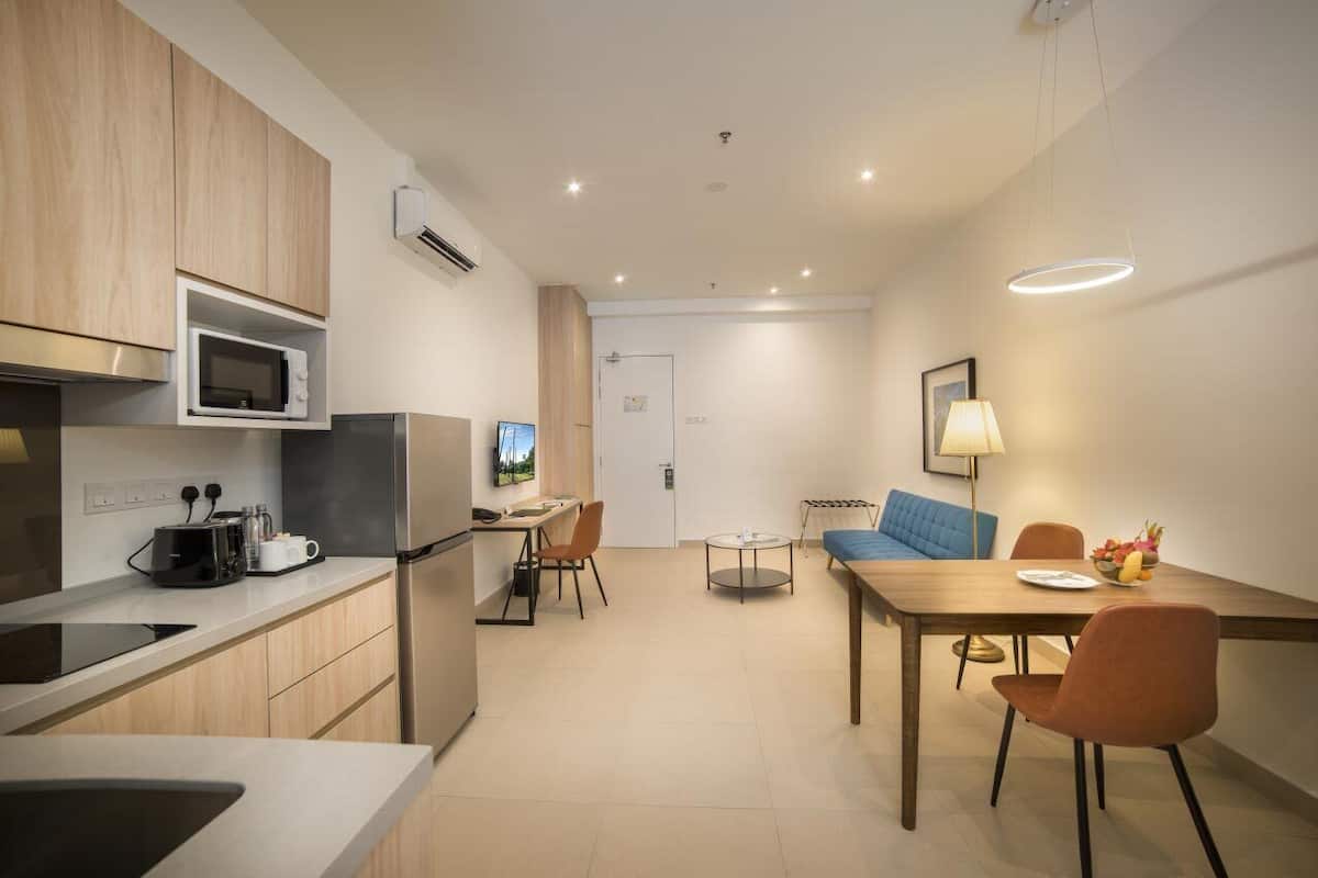 A modern kitchen with a microwave, stove, and dining area with a table and chairs.