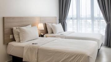 A hotel room with two beds, a wooden headboard, a bedside lamp, and a view of the city through large windows.